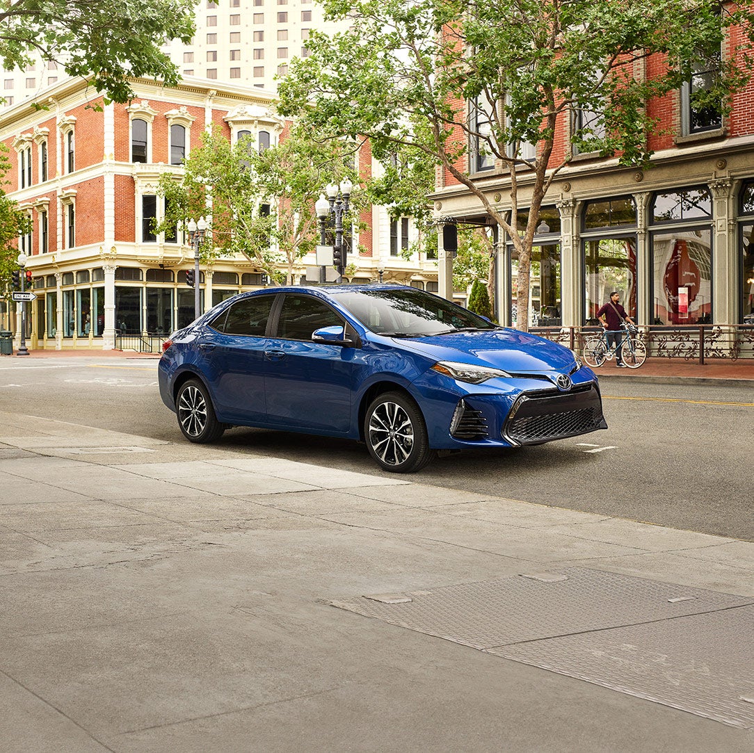 Can I trade in my leased vehicle at Fiore Toyota in Hollidaysburg | Blue MY19 Corolla Parked on City Street